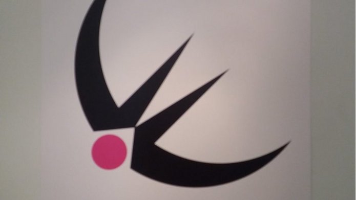 geometryczny czarno-różowy znak przypominający jaskółkę